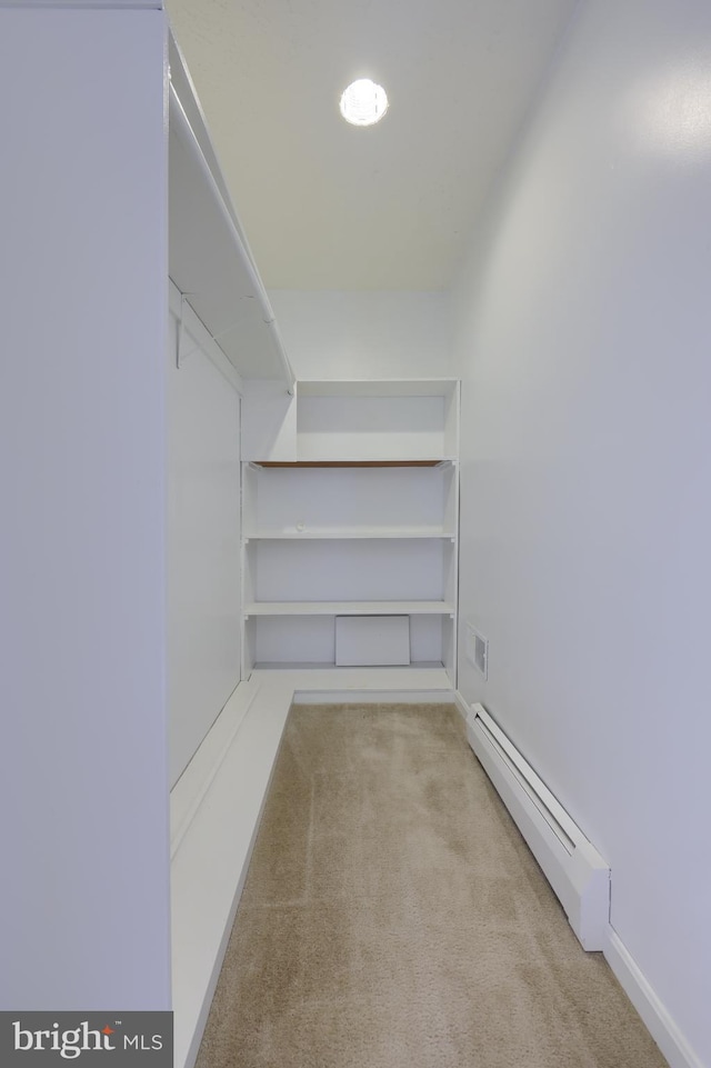spacious closet featuring carpet flooring and a baseboard radiator