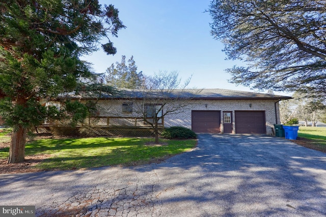 view of front of property featuring a front lawn, a deck, aphalt driveway, and a garage