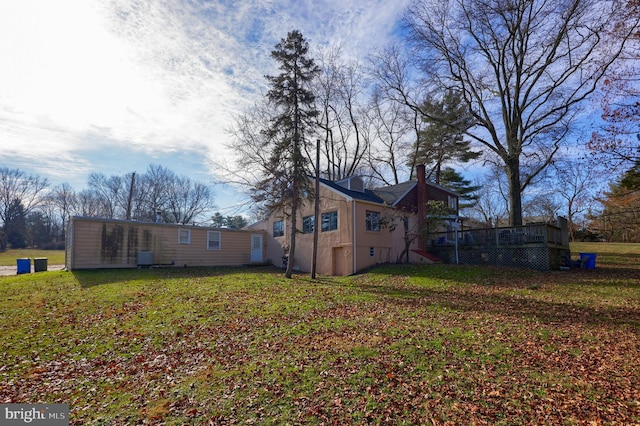 view of side of home featuring a yard and a deck