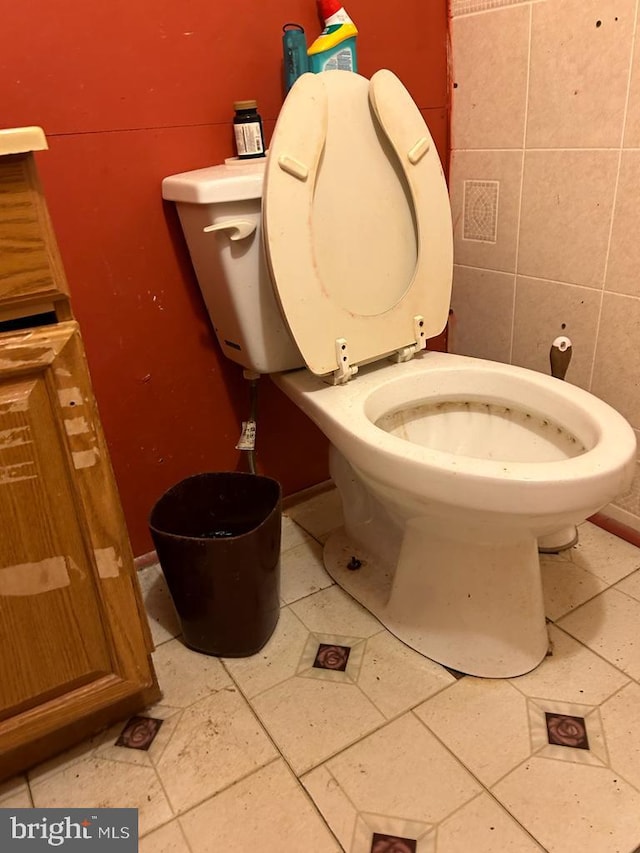 bathroom with toilet and tile walls