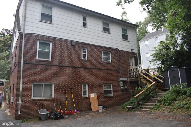 rear view of house featuring a shed