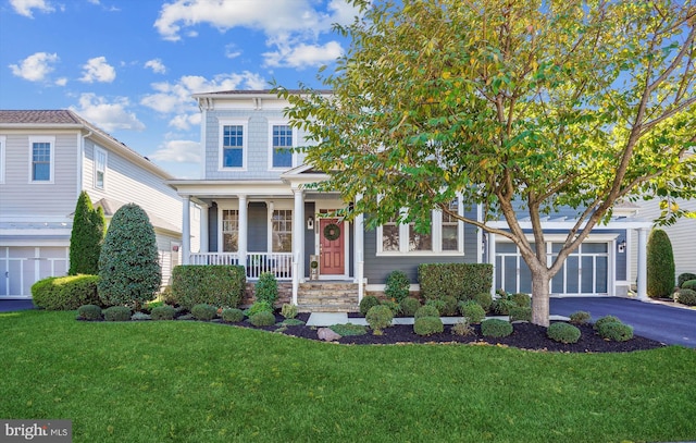 view of front of property with a porch, a garage, and a front yard