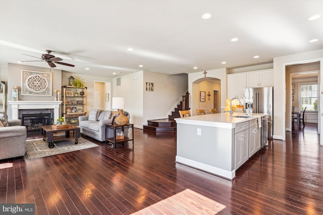 kitchen featuring sink, white cabinetry, stainless steel appliances, dark hardwood / wood-style floors, and an island with sink