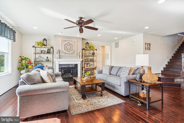 living room featuring dark wood-type flooring and ceiling fan