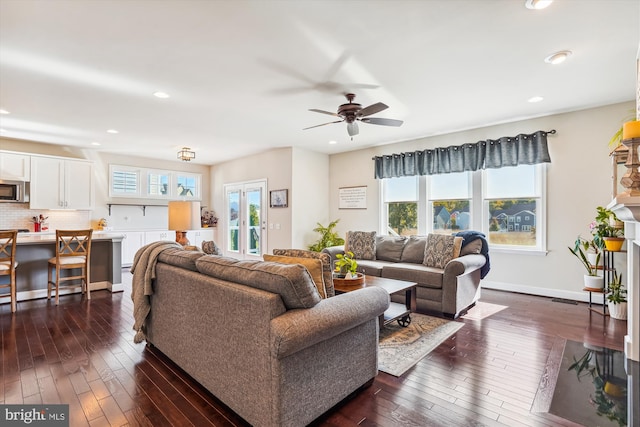 living room featuring dark hardwood / wood-style floors, a wealth of natural light, and ceiling fan