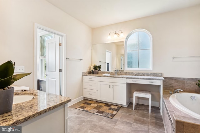 bathroom featuring vanity and tiled tub