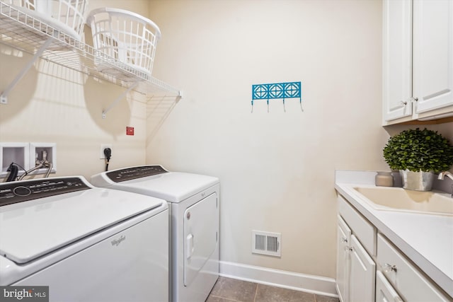 laundry area with sink, light tile patterned floors, washer and clothes dryer, and cabinets