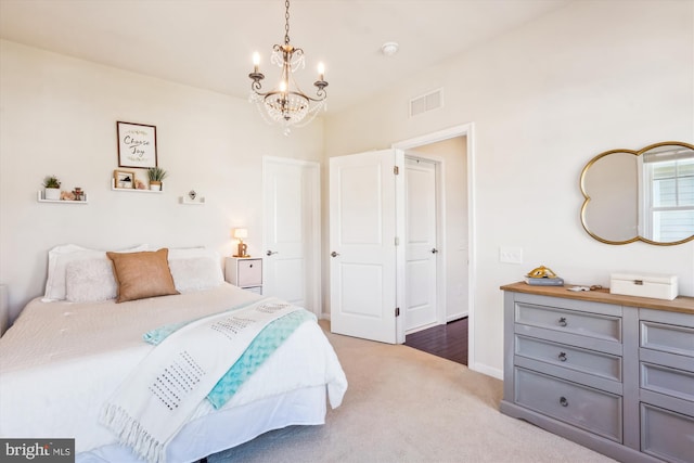 bedroom featuring light colored carpet and a chandelier