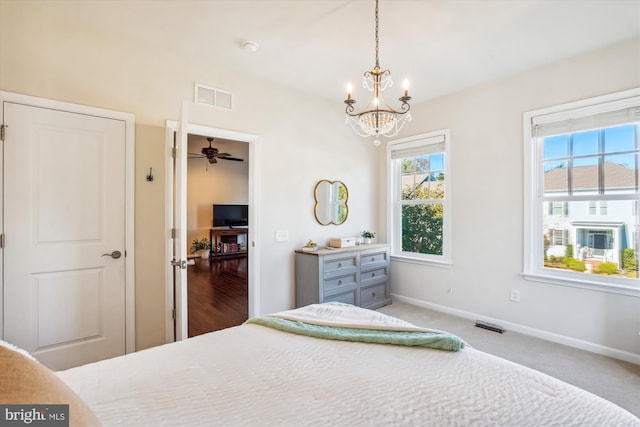 carpeted bedroom featuring an inviting chandelier