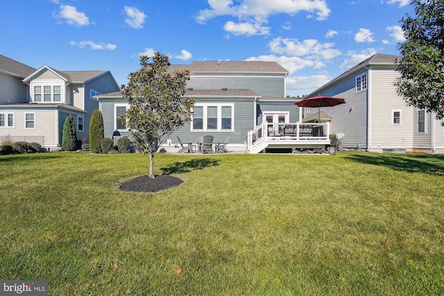 back of property with a wooden deck and a lawn