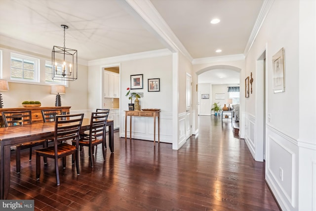 dining area with crown molding, dark hardwood / wood-style floors, and a chandelier