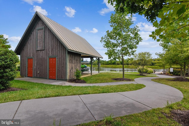 view of outbuilding featuring a water view and a yard