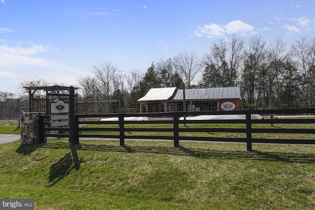 view of gate with a yard and an outbuilding