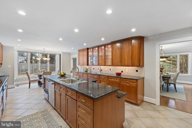 kitchen with dishwasher, decorative backsplash, brown cabinetry, and a sink