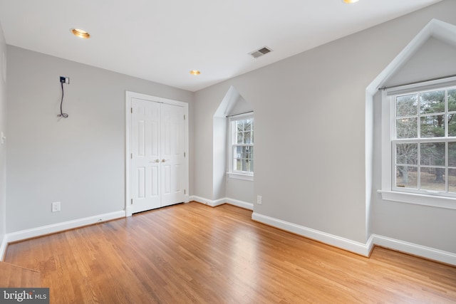 unfurnished bedroom with light wood-type flooring, baseboards, and visible vents