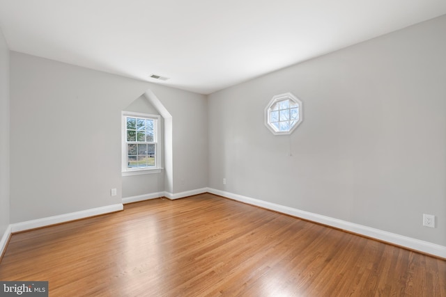 unfurnished room with visible vents, light wood-style flooring, and baseboards