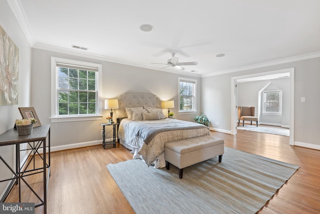 bedroom featuring visible vents, crown molding, multiple windows, and wood finished floors