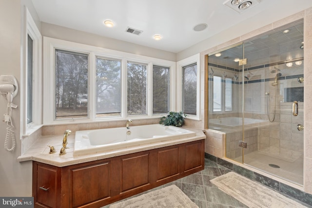 bathroom with a garden tub, visible vents, and a stall shower