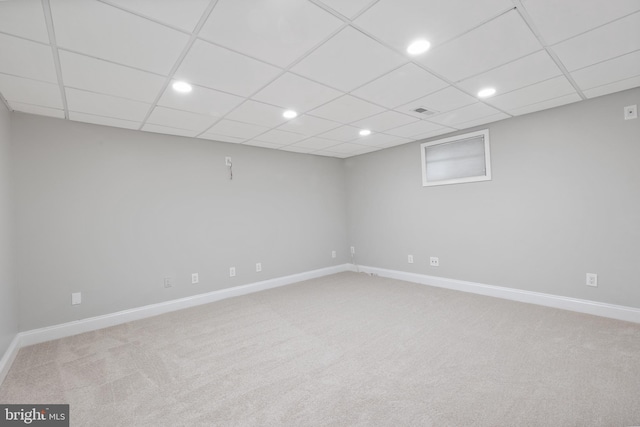 finished below grade area featuring a drop ceiling, recessed lighting, carpet flooring, visible vents, and baseboards