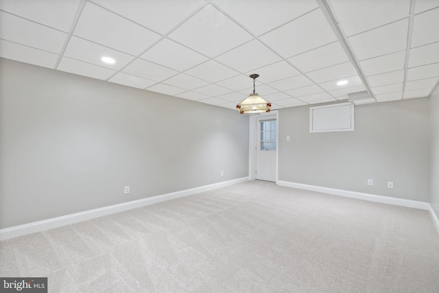 carpeted empty room featuring baseboards, a drop ceiling, and recessed lighting