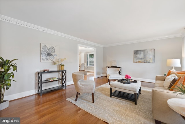 living room featuring crown molding, wood finished floors, and baseboards