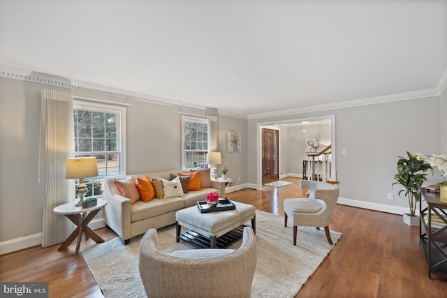 living room featuring baseboards, wood finished floors, and crown molding