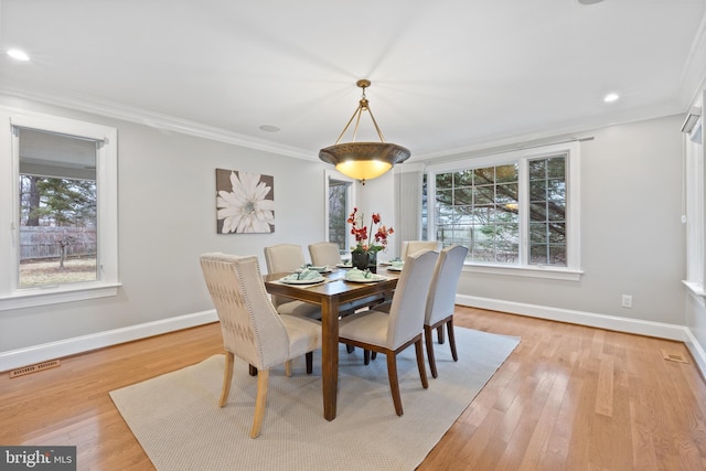 dining space featuring baseboards, a wealth of natural light, visible vents, and crown molding