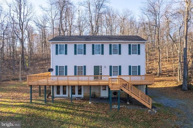 view of front facade with a front yard and a wooden deck