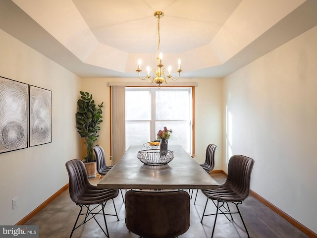 dining space featuring a chandelier and a raised ceiling