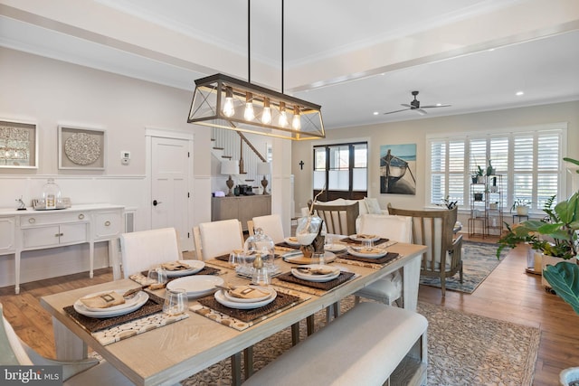 dining space featuring ornamental molding, beamed ceiling, wood-type flooring, and ceiling fan