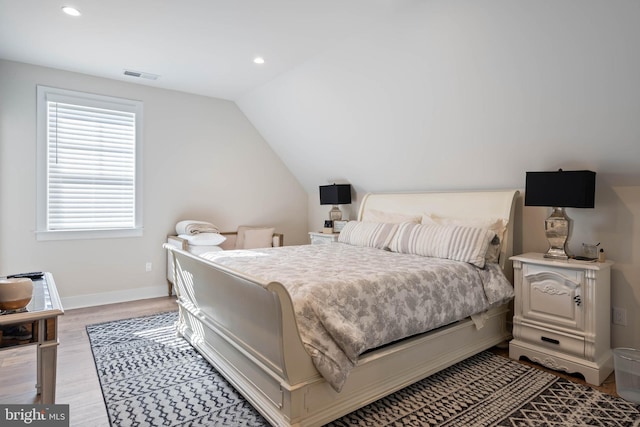 bedroom with lofted ceiling and hardwood / wood-style floors