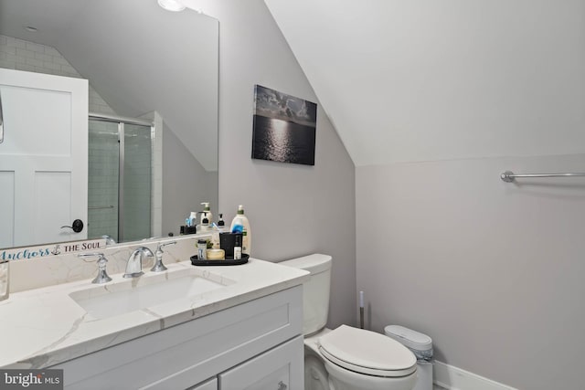 bathroom with toilet, vanity, vaulted ceiling, and a shower with door