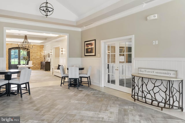 dining space with french doors, a chandelier, crown molding, and vaulted ceiling