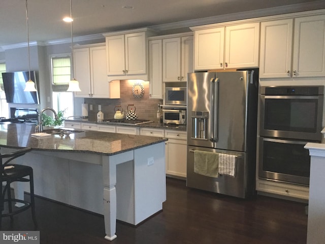 kitchen featuring crown molding, stainless steel appliances, sink, and a kitchen island with sink