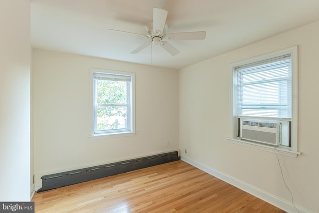 empty room with light hardwood / wood-style floors, cooling unit, a baseboard heating unit, and ceiling fan