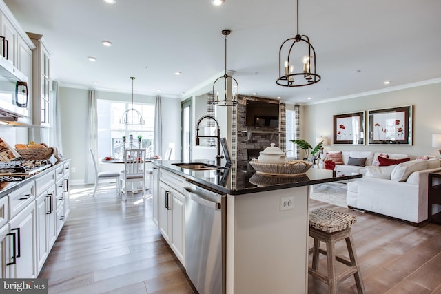 kitchen with sink, stainless steel appliances, white cabinets, dark wood-type flooring, and a kitchen island with sink