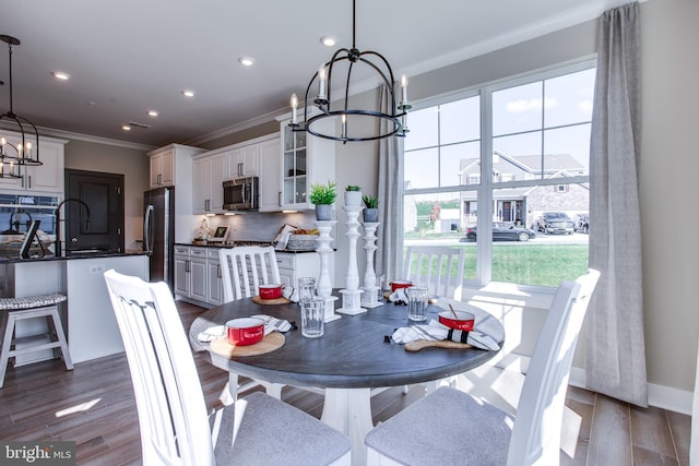 dining area featuring crown molding, a notable chandelier, and dark hardwood / wood-style floors