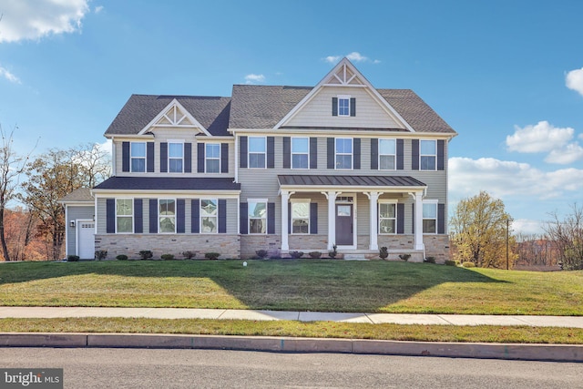 view of front of home featuring covered porch, a garage, and a front lawn