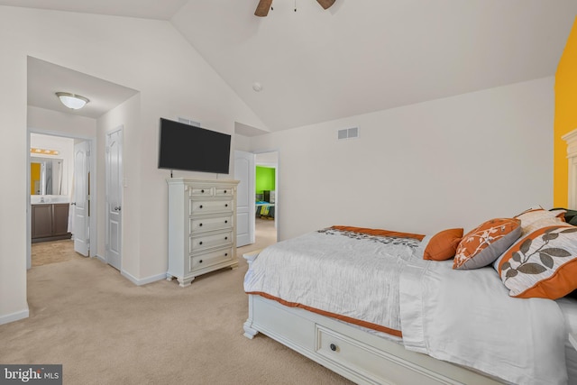 carpeted bedroom with ensuite bathroom, ceiling fan, and vaulted ceiling