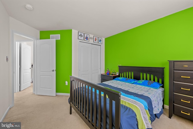 bedroom featuring light carpet and a closet