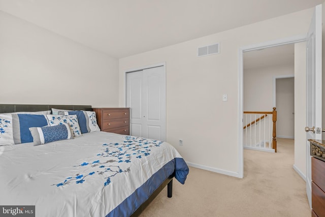 bedroom with light colored carpet and a closet