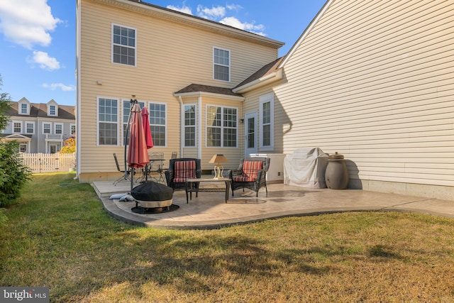 back of property with a patio, a fire pit, and a lawn