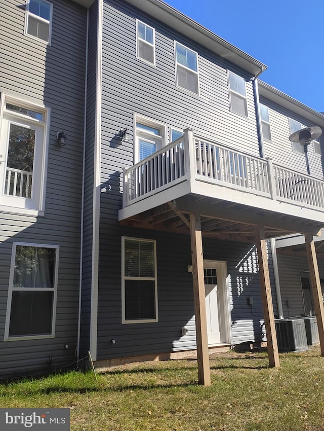 rear view of house featuring a deck, a yard, and central AC unit