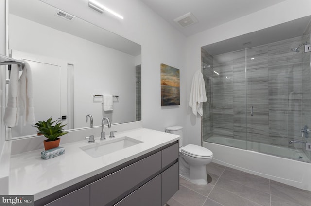 full bathroom featuring vanity, combined bath / shower with glass door, toilet, and tile patterned flooring