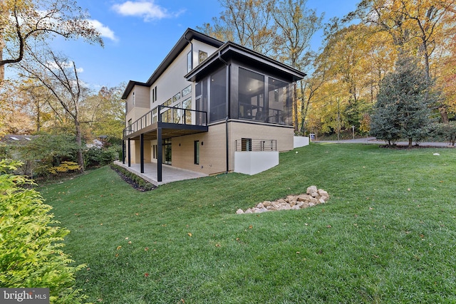 back of house with a patio, a lawn, and a sunroom