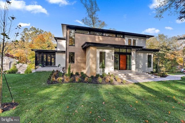 rear view of property with a patio, a yard, and a sunroom