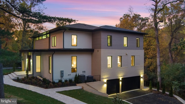 back house at dusk with a garage