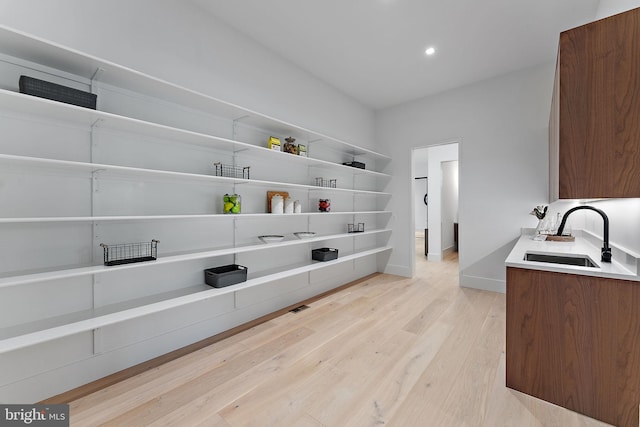 laundry room with sink and light wood-type flooring