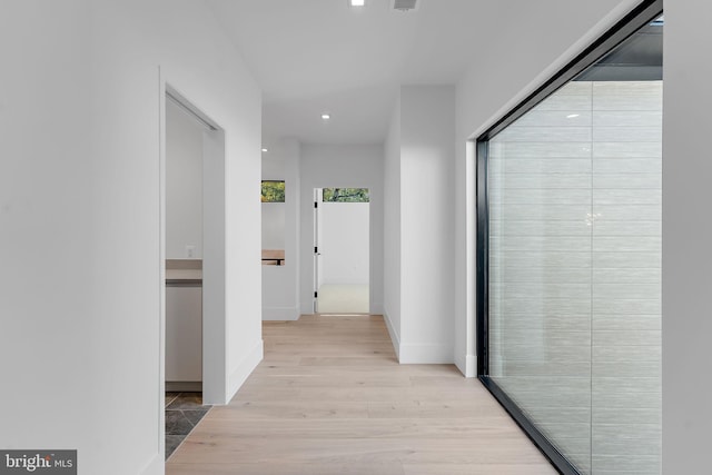 hallway with light hardwood / wood-style floors