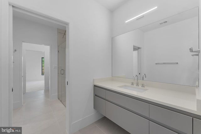 bathroom with vanity, a shower with shower door, and tile patterned flooring